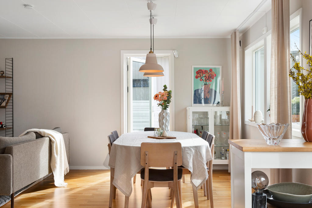 Matplats med utgång till terrass i kvällssol, och den perfekta trädgården. 