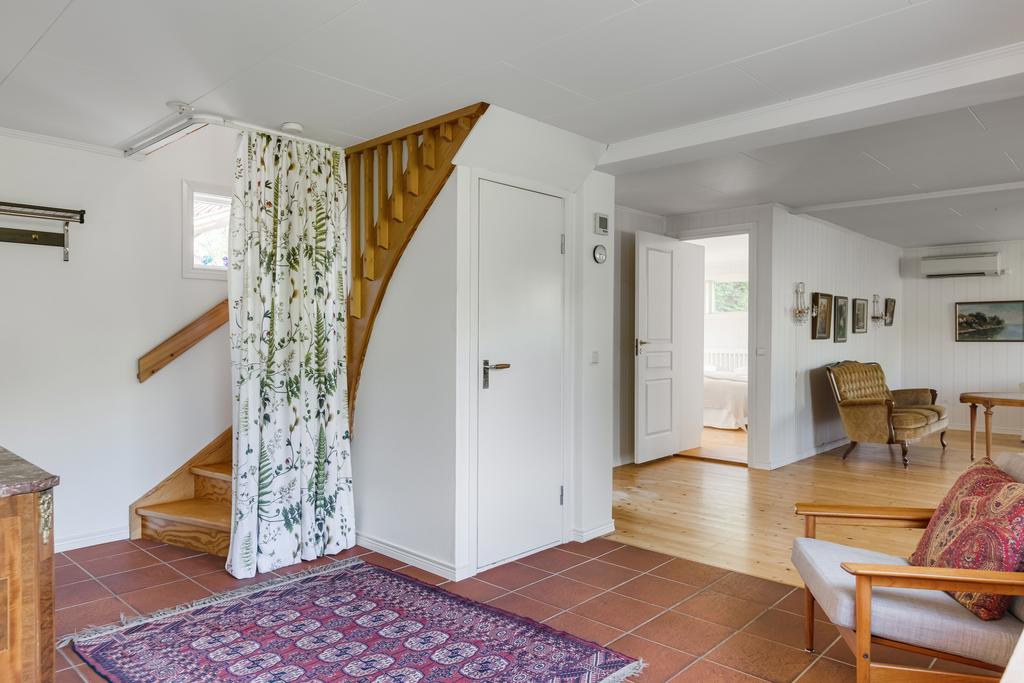 Hall med klinkergolv, plats för avhägning och trappa till andra våning.