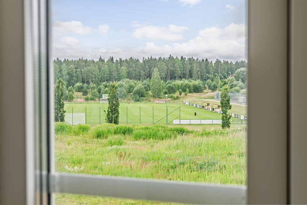 Utsikt över grönområde och Skogshöjdens Idrottsanläggning.