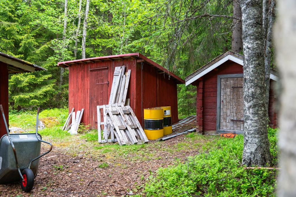 Vedbod och utedass på tomten.