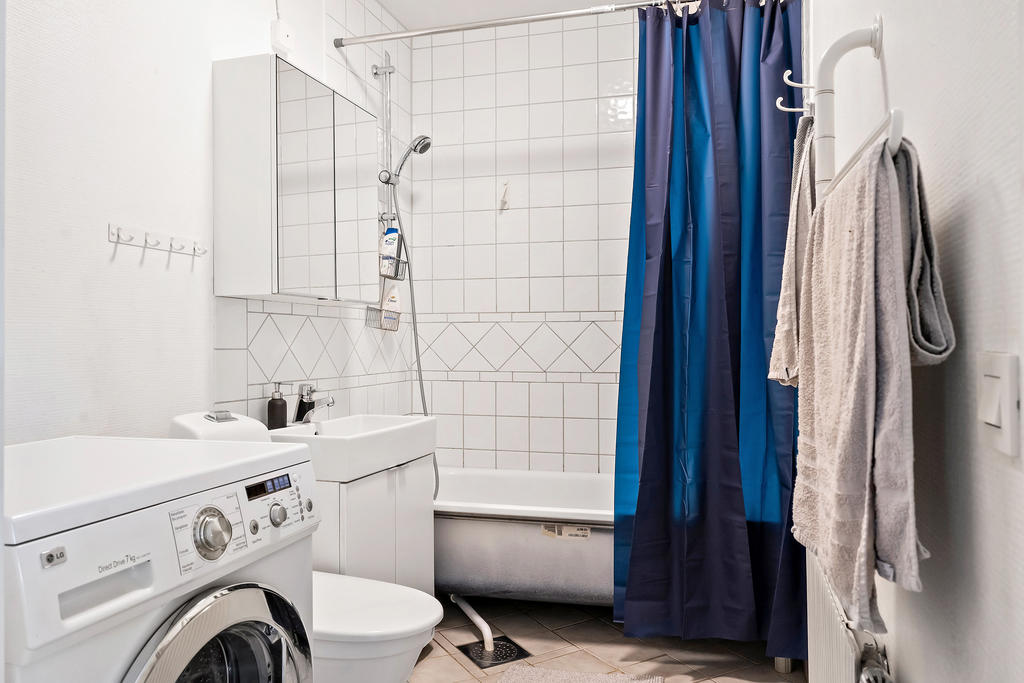Badrum med tvättmaskin och badkar