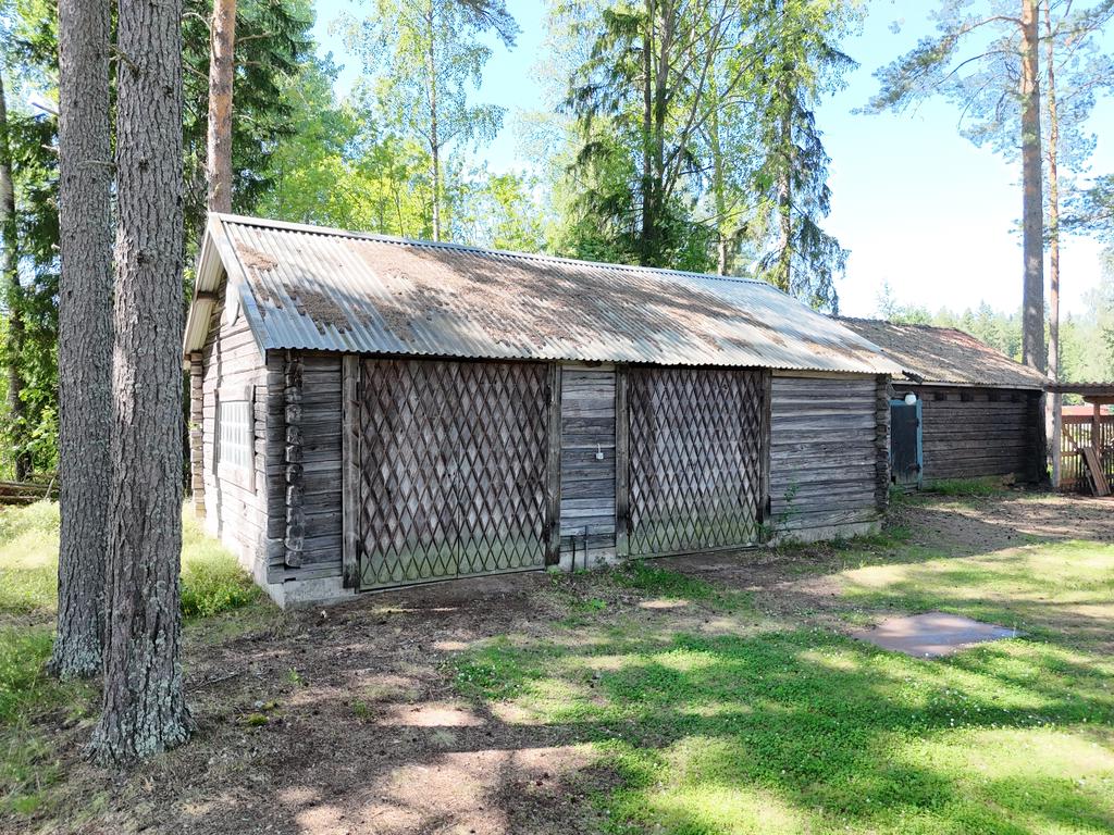 Traktorgarage och virkeslada till höger