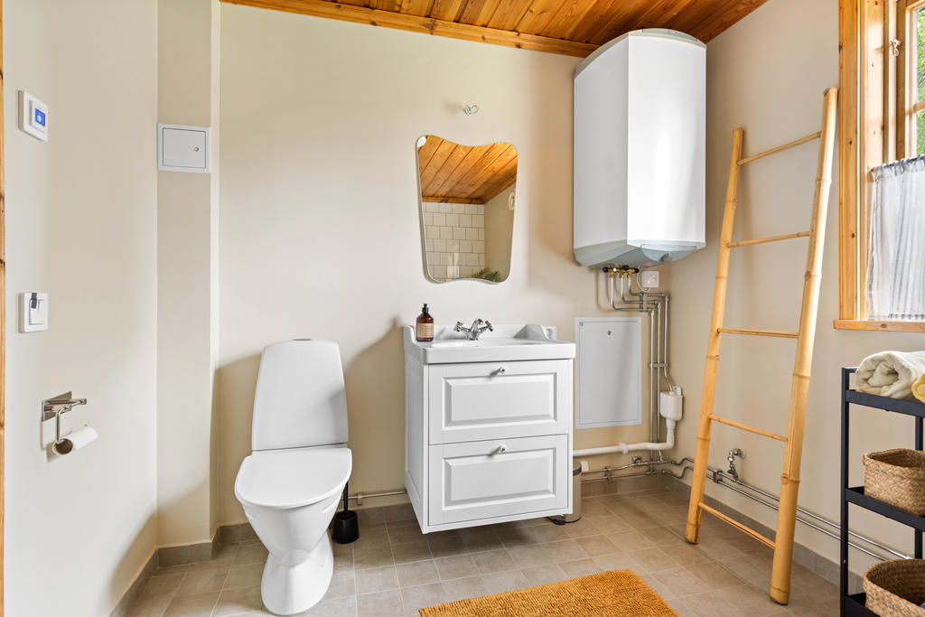 Duschrum/tvättstuga med wc, handfat, dusch, tvättmaskin och varmvattenberedare
