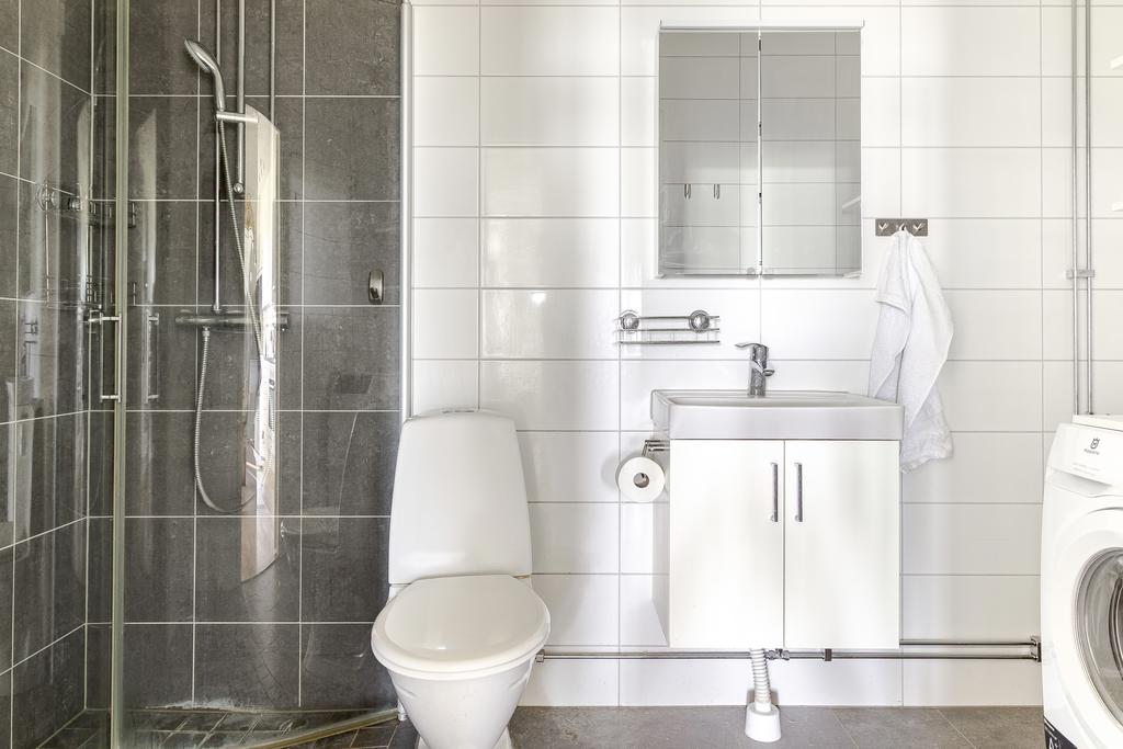 Till höger om hallen finns bostadens helkaklade badrum med tvättutrymme.