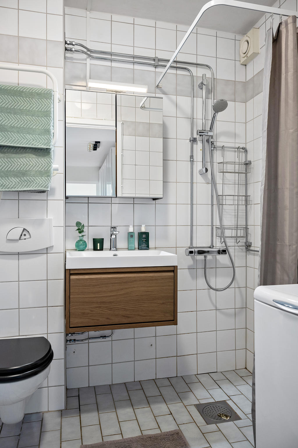 Helkaklat badrum med dusch och tvättmaskin