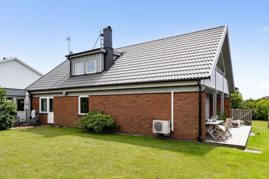 På baksidan av huset finns en stor gräsmatta som passar perfekt för sommarens aktiviteter.