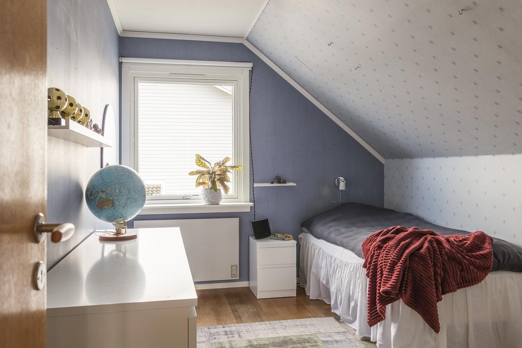 Ytterligare ett sovrum med snedtak. Sovrummet är utrustad med laminatgolv.