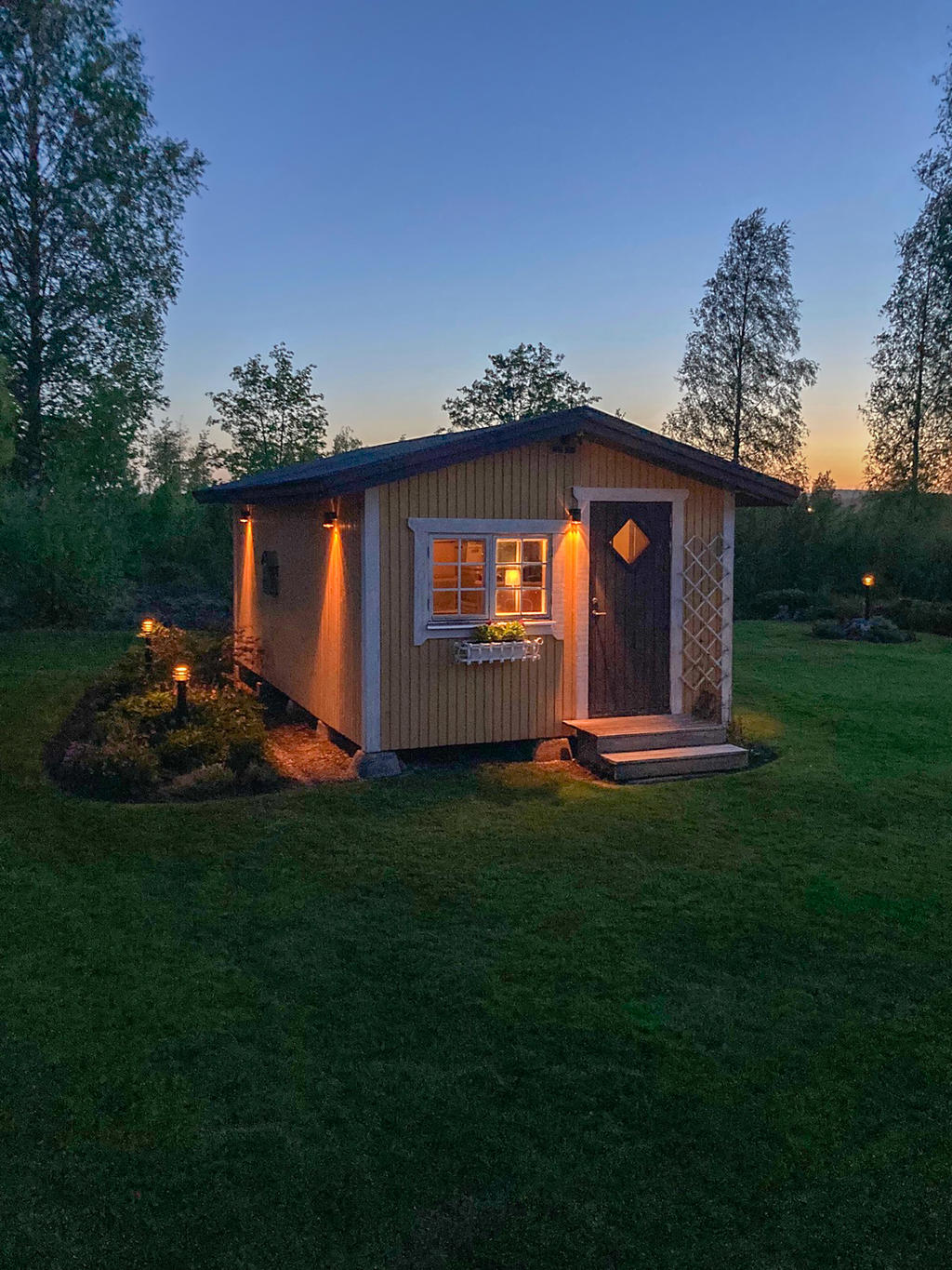 Kvällsbild på stuga/förråd (kundfoto)