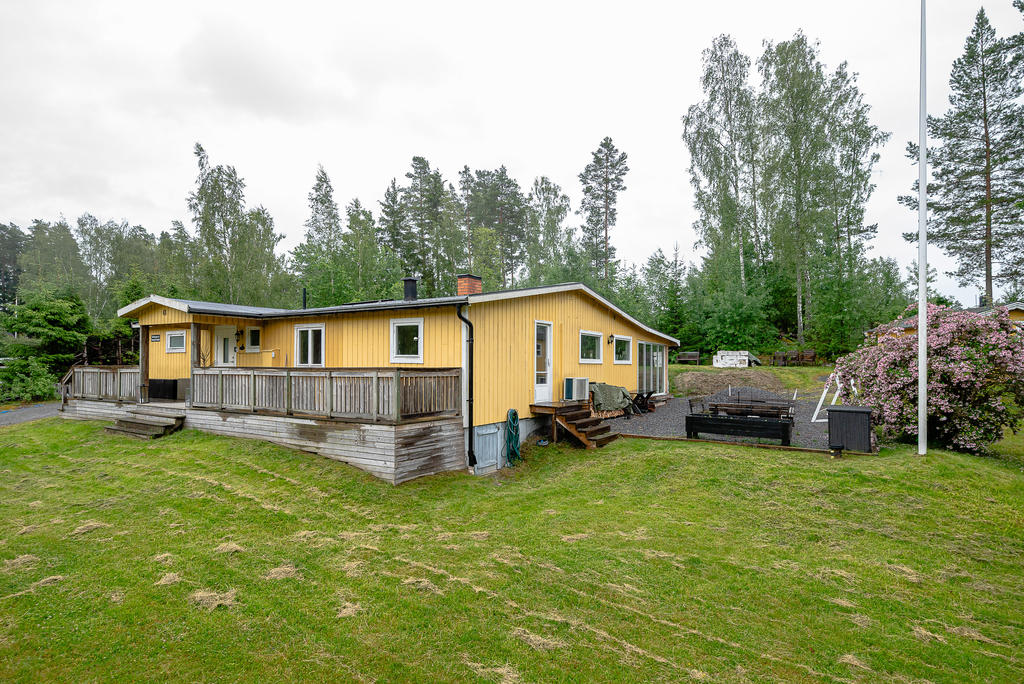Välkomnande entré med uteplats. Ytterligare uteplats med grusat underlag, på husets gavel. 