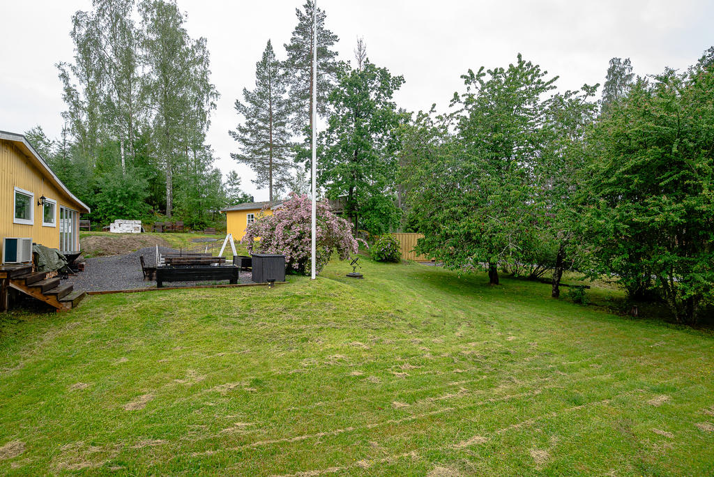 Uteplats, flaggstång och gästhus