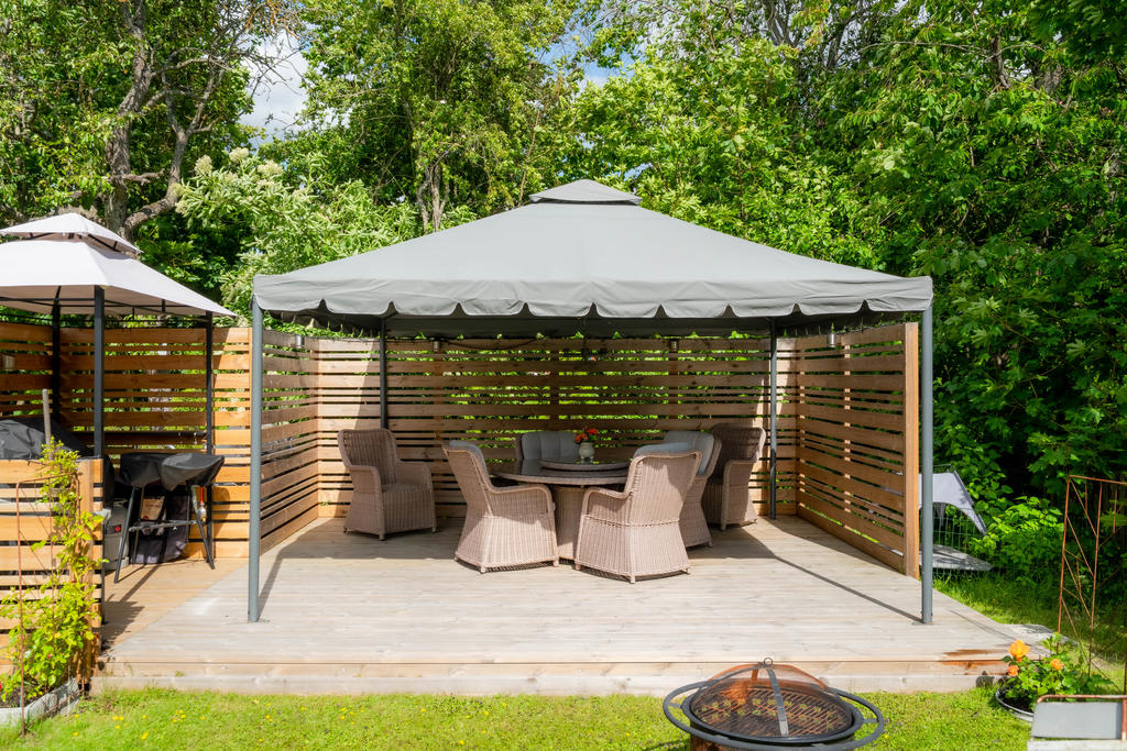 Pergola och altandäck för sköna sommarkvällar bland skyddande träd