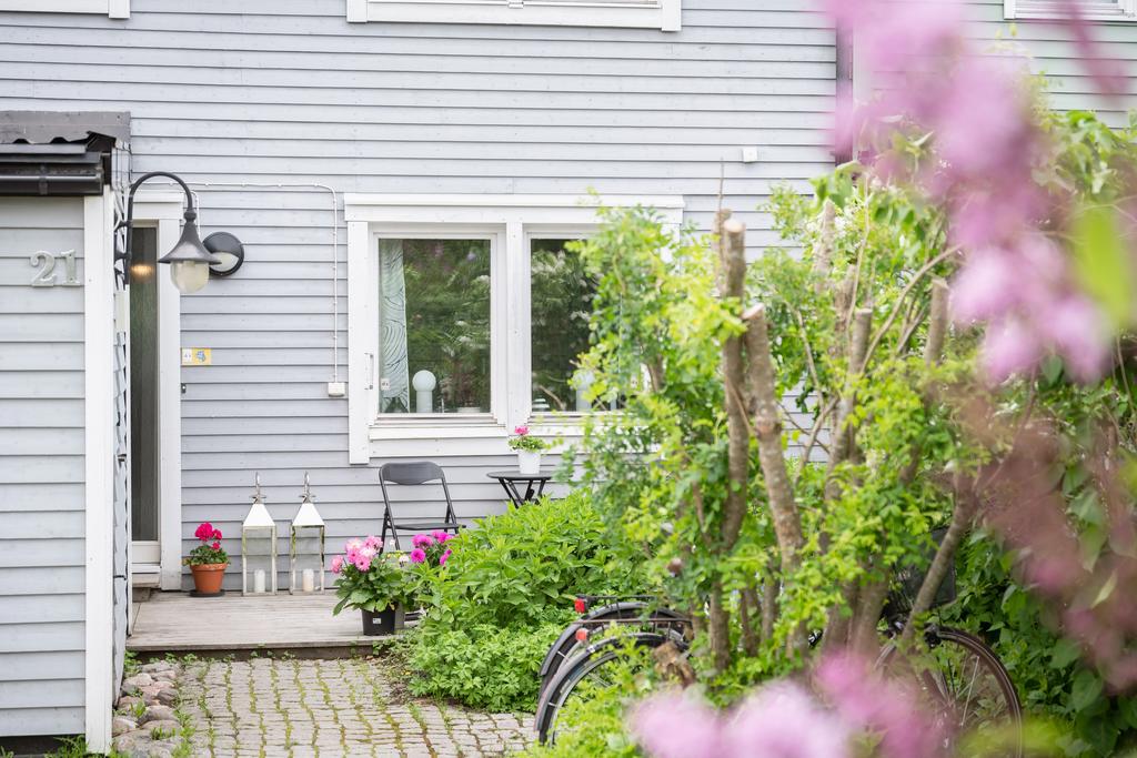 Härlig framsida av huset med altan, stensättning och växter
