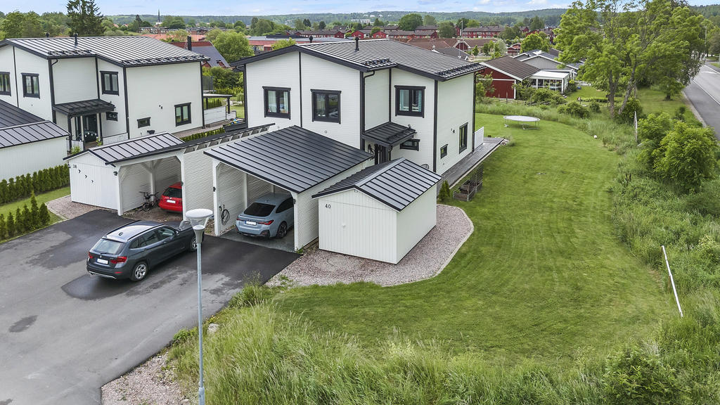 Asfalterad uppfart med carport och förråd