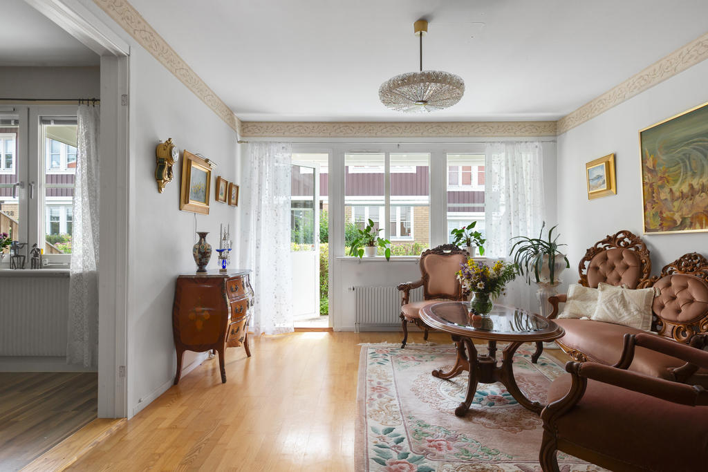 Vardagsrum med utgång till bostadens altan på framsidan och ingång till bostadens första sovrum