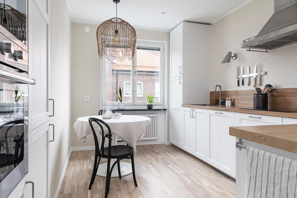 Ljust härligt kök med matplats och inbyggda vitvaror