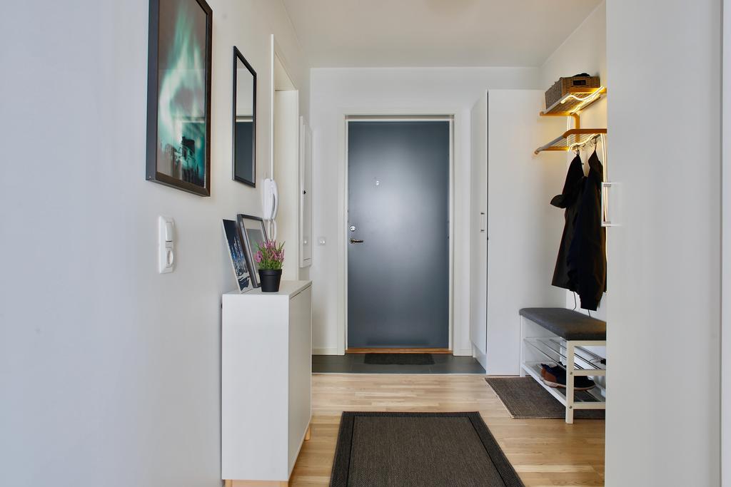 Ingång till hall med klinker närmast entrén och enhetligt, vitlaserat ekparkettgolv