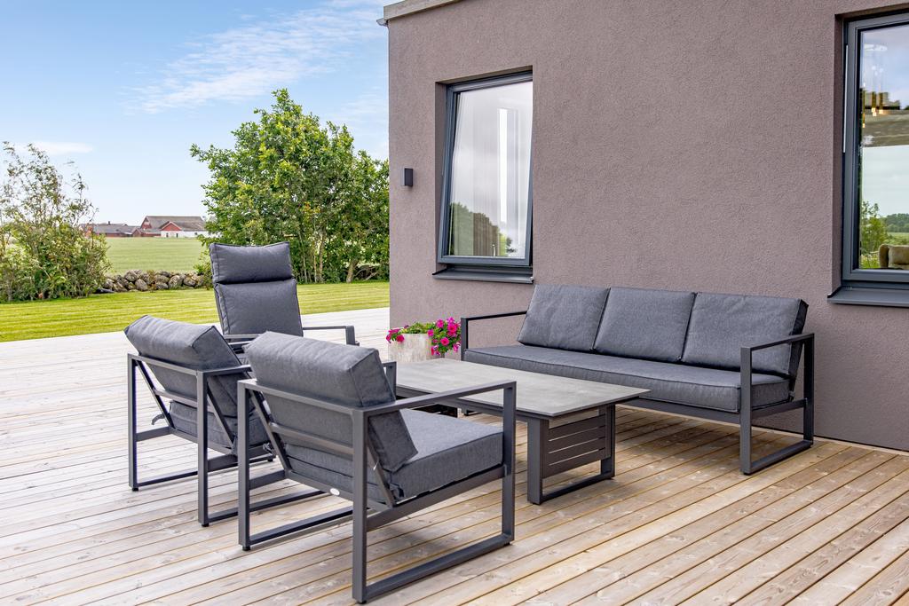 En inbjudande loungehörna angränsar till vardagsrummet, perfekt för avkoppling och social samvaro i en avslappnad miljö.