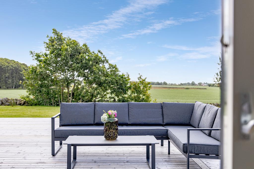 Generös trädgård som ramas in av natur och fält – barnvänlig och lättskött