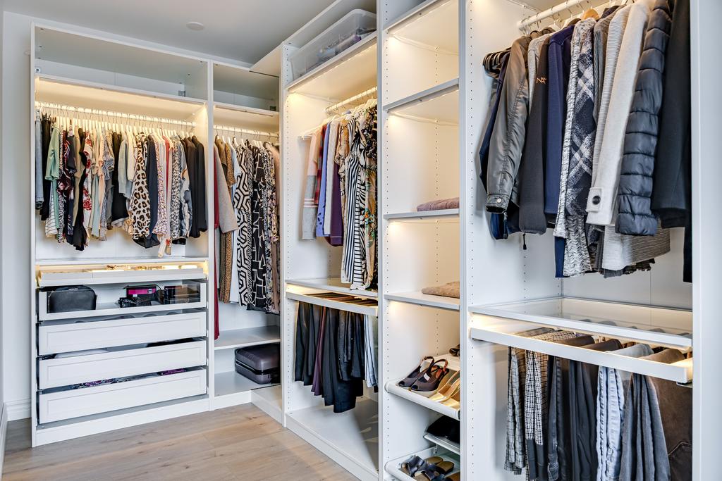 Den öppna planlösningen i klädkammaren underlättar en smidig och effektiv förvaring, vilket gör det enkelt att organisera och komma åt överblivna kläder och tillbehör. 