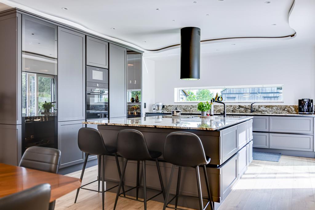 Exklusivt kök med köksö, sittplatser och mörka snickerier. Här finns även nersänkt takbelysning. -----måste göras om