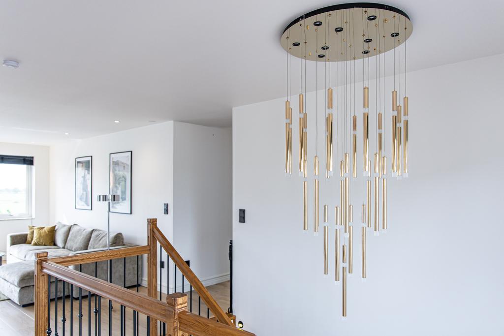 Modern belysningskrona över trappuppgången som ingår i försäljning i samband med fastigheten. 