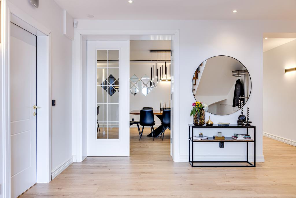 Elegant hall med parinnedörrar och ljusinsläpp från flera håll.