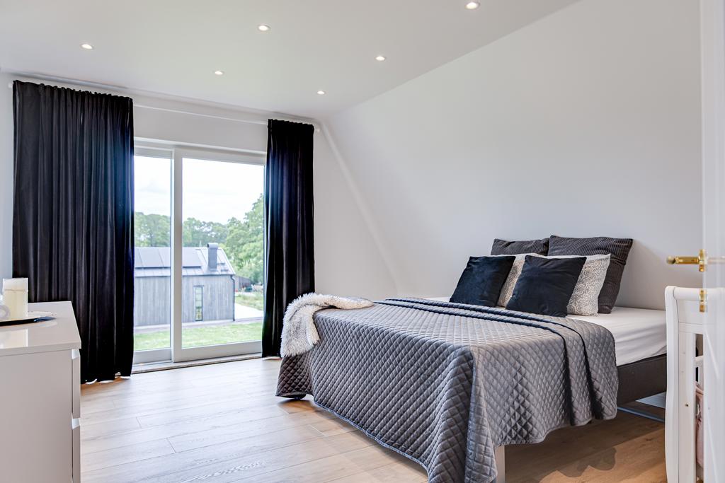 Sovrum på andra våning med spotlights och och franskbalkong. 