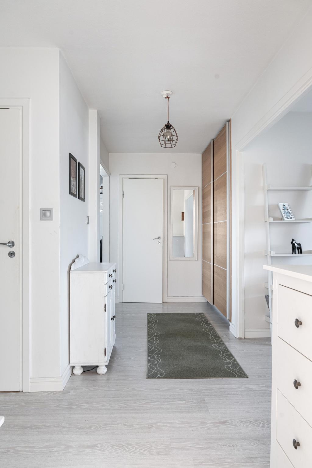 Vy från hallen, praktiskt och stilrent! Här möts du av gott om förvaring i form av platsbyggda garderober och generösa avhängningsmöjligheter.