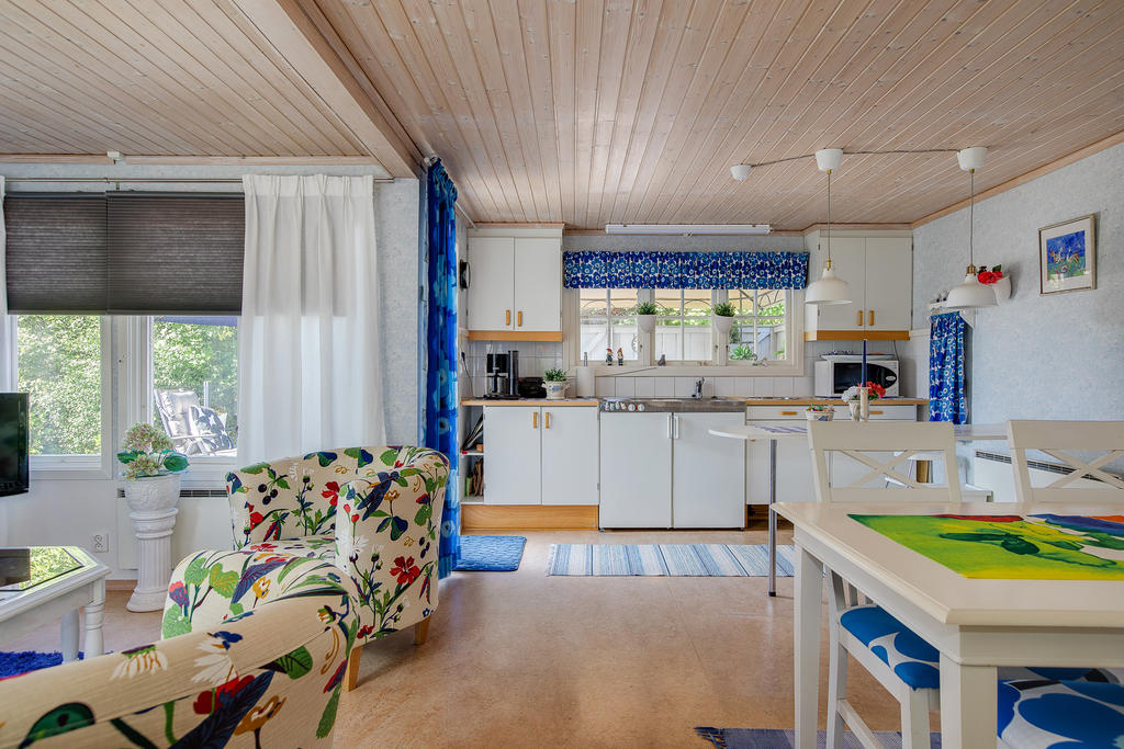 Kök med microvågsugn, spis och vask. Ugn i förrådsbyggnad