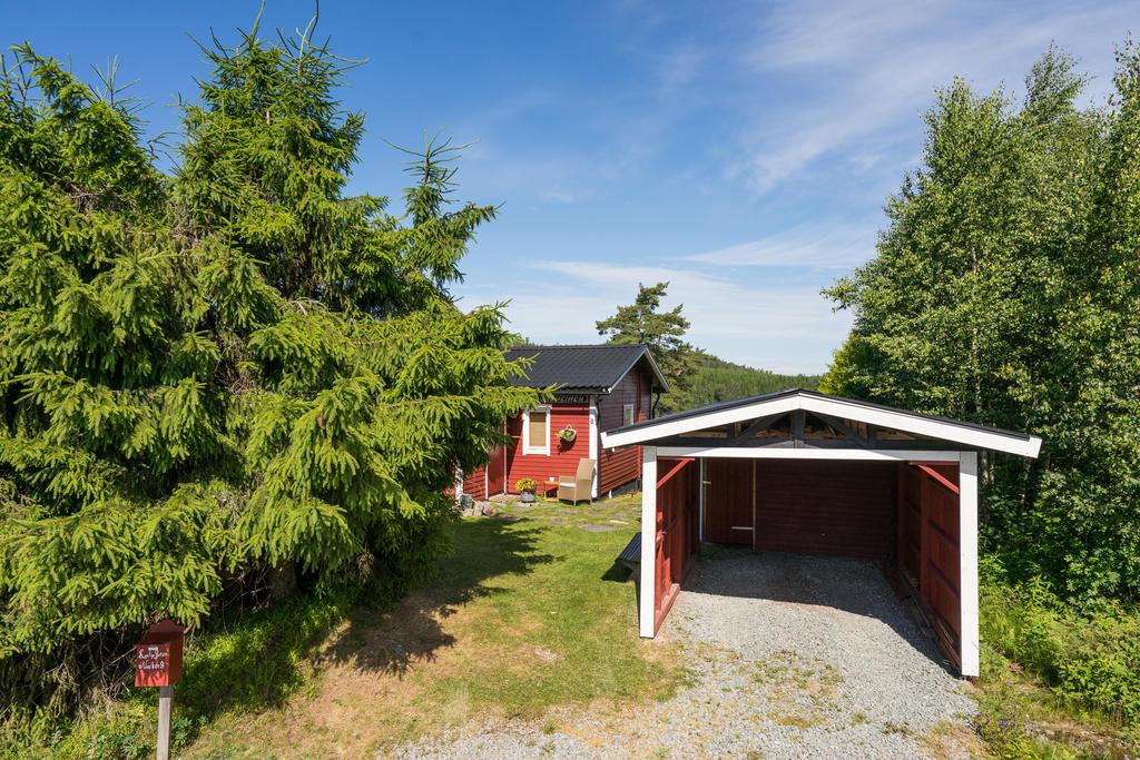 Rymlig carport med laddare för elbil. 