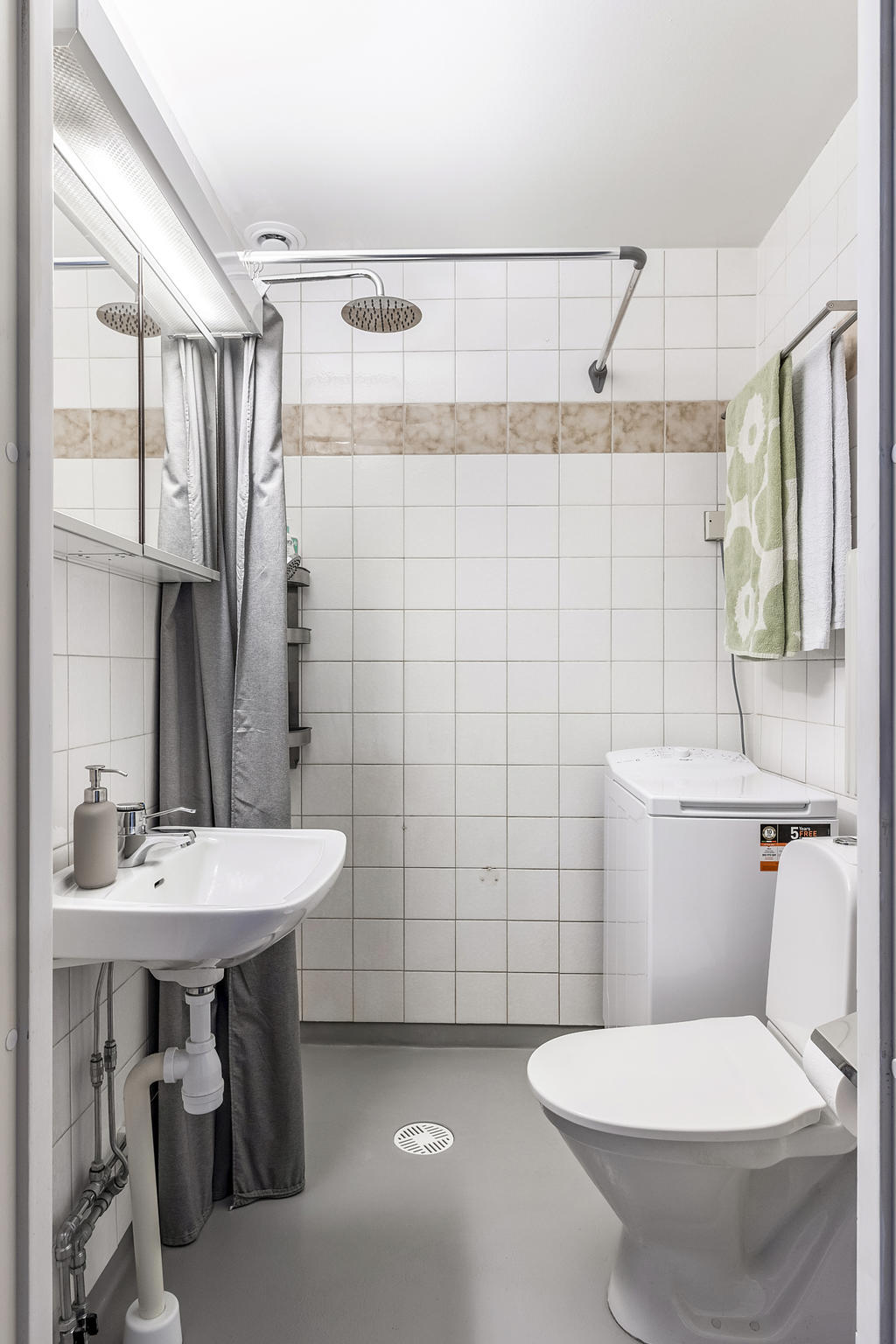 Badrum med dusch och plats för tvättmaskin