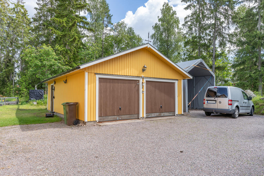 Fristående dubbelgarage med gjuten platta, el och elbilsladdare. Förråd och hobbyrum intill.