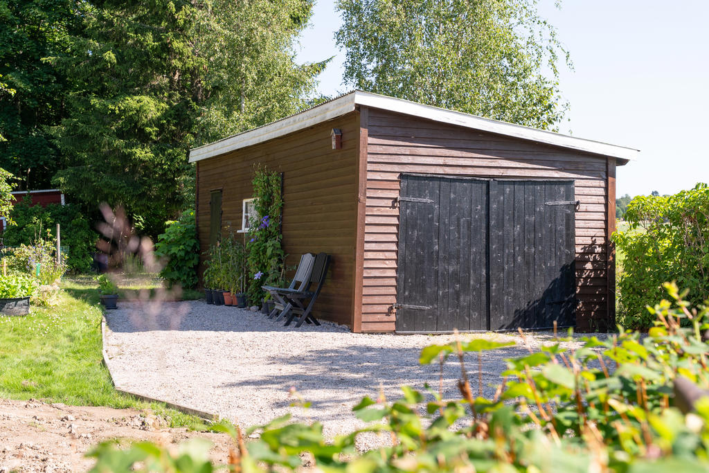 Fristående garage med grusad uppfart.