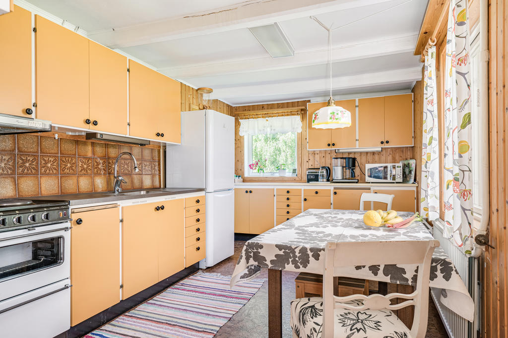 Funktionellt kök i tidstypisk  äldre stil med plats för matgrupp. 