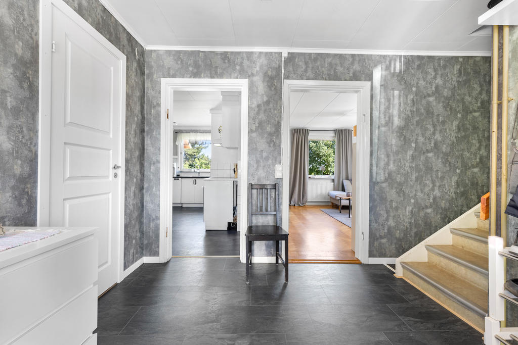 Renoverad hall med trapp till övervåning.