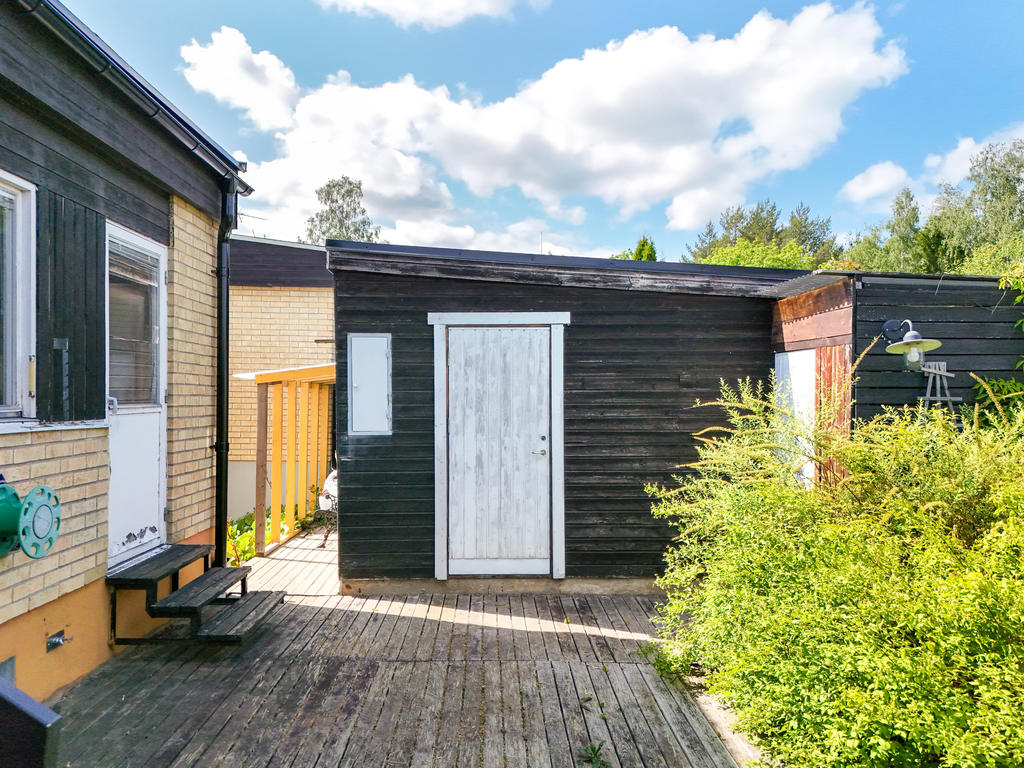 Uteplats intill entrén och köket, samt ingång till garage. 