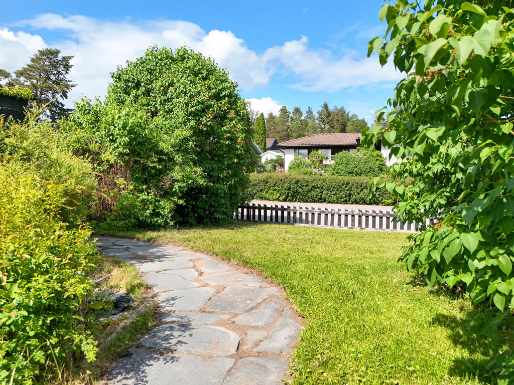 Trädgård med stengång på framsidan. 