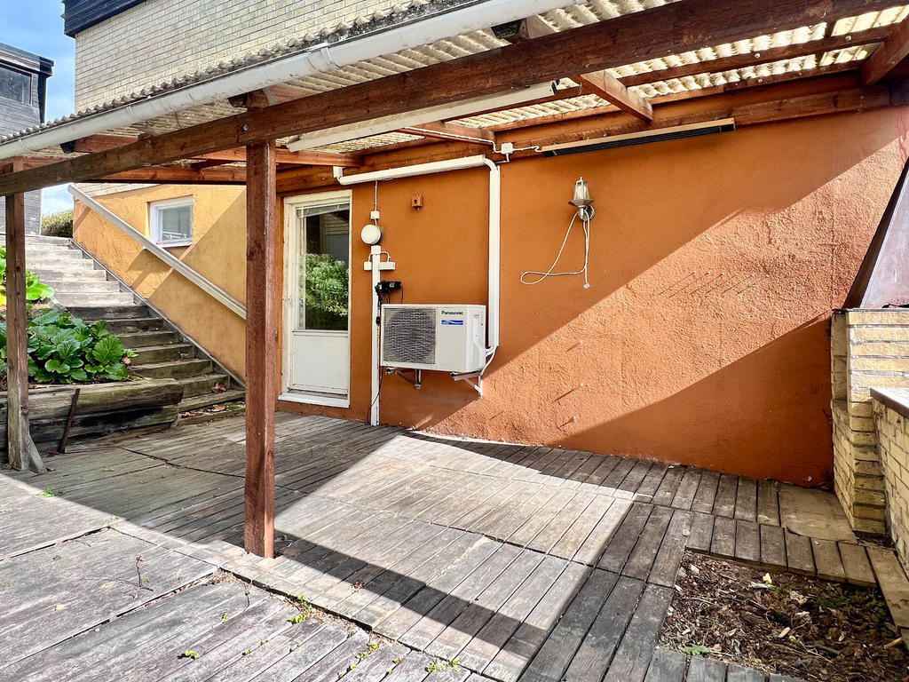 Uteplats under tak i anslutning till suterrängplan.