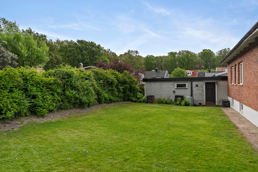 Trädgård med åtkomst till garage med bastu