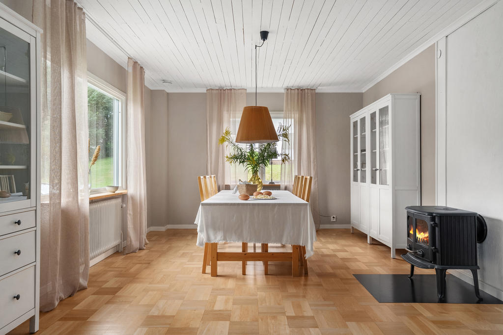 Stort vardagsrum med matsalsdel och braskamin