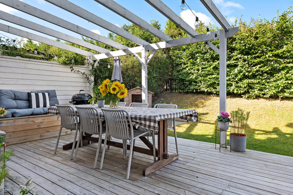 Gott om plats för utemöbler på terrassen, ombonat med pergola