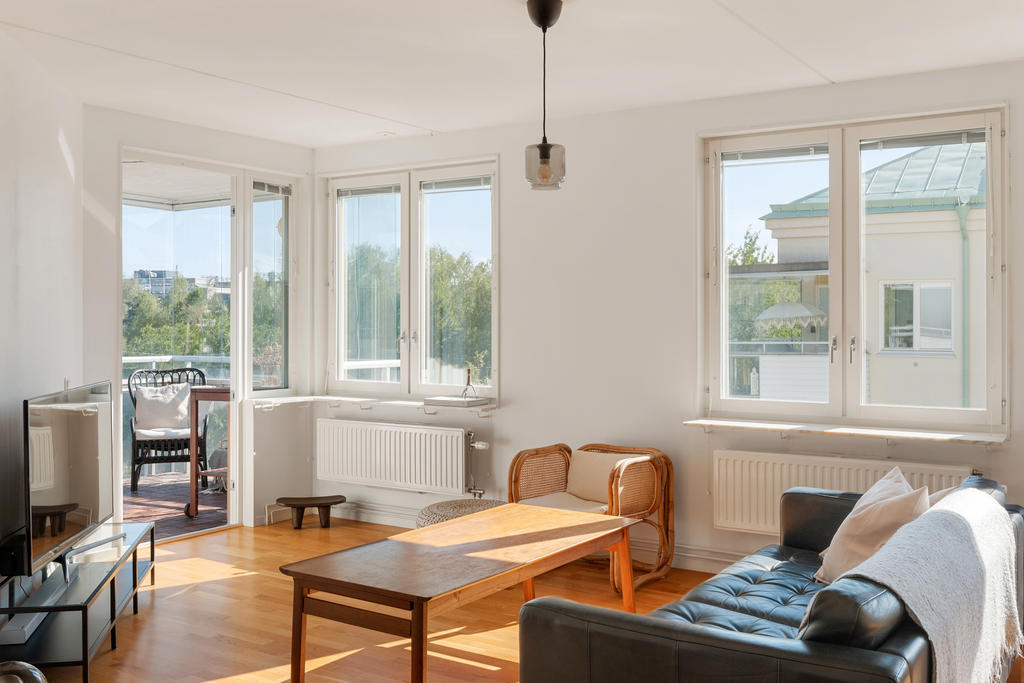 Vardagsrummet med utgång till den stora inglasade balkongen.
