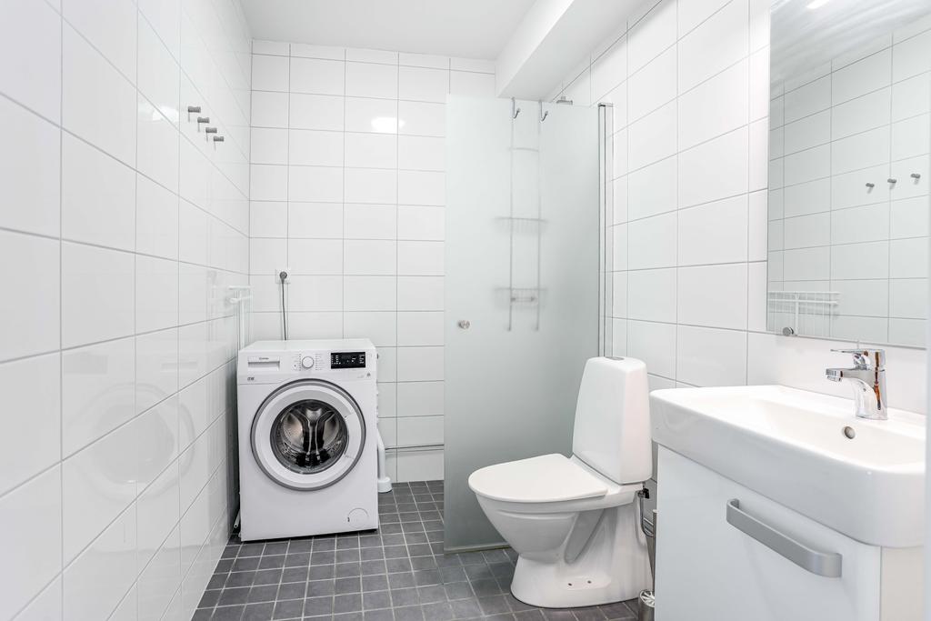 Badrum med duschplas och tvättmaskin
