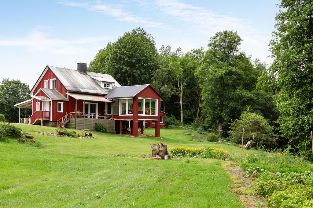 På baksidan öppnar sig altandäcket mot stora gräsytor – perfekt för grillkvällar och familjeliv.