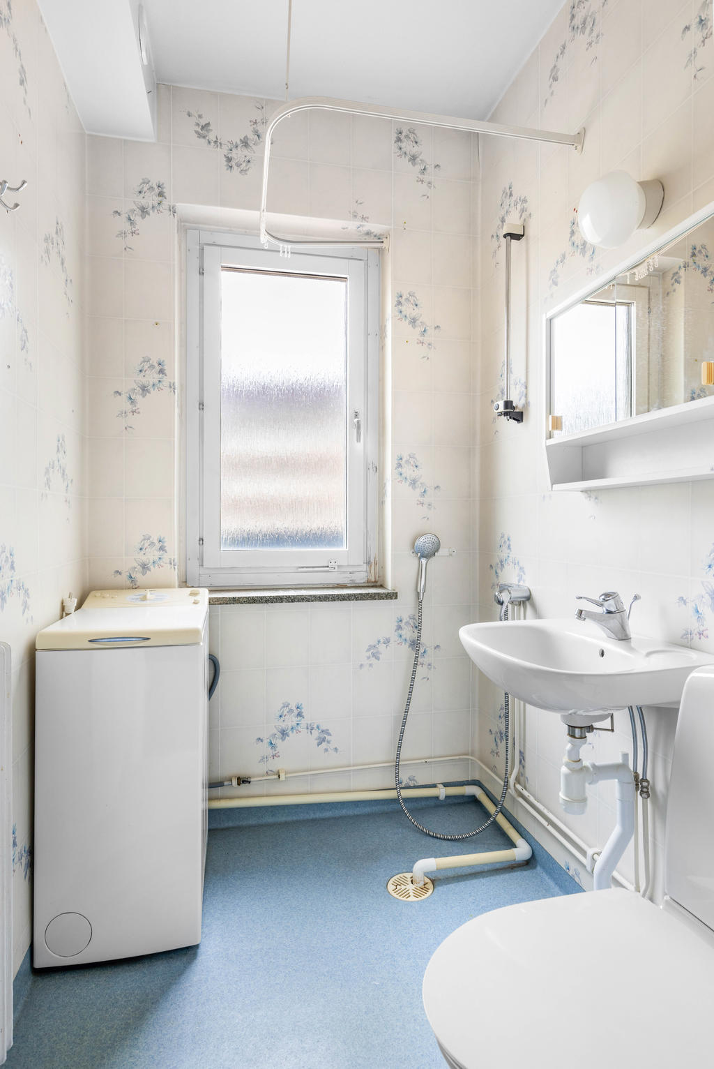 Duschrum med wc, handfat, dusch och toppmatad tvättmaskin