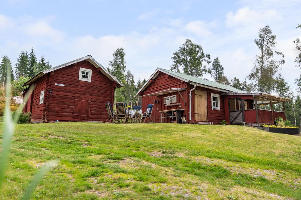 Det timrade härbret/uthuset och huvudstugan