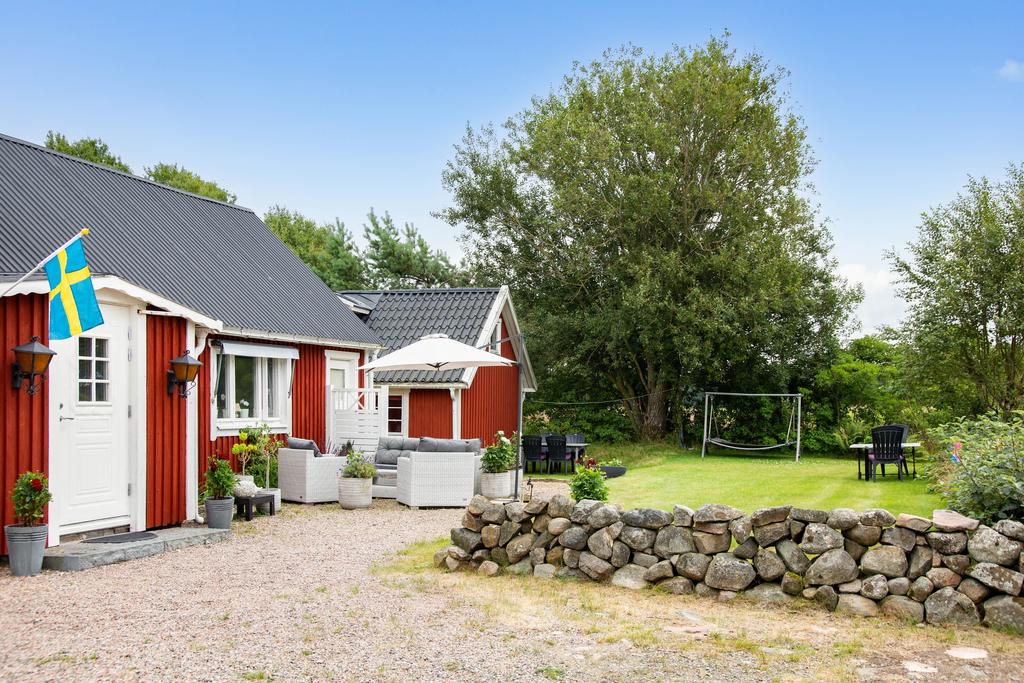 På framsidan välkomnas du av en fin trädgård, vackert inramad av en klassisk stengärdsgård.
