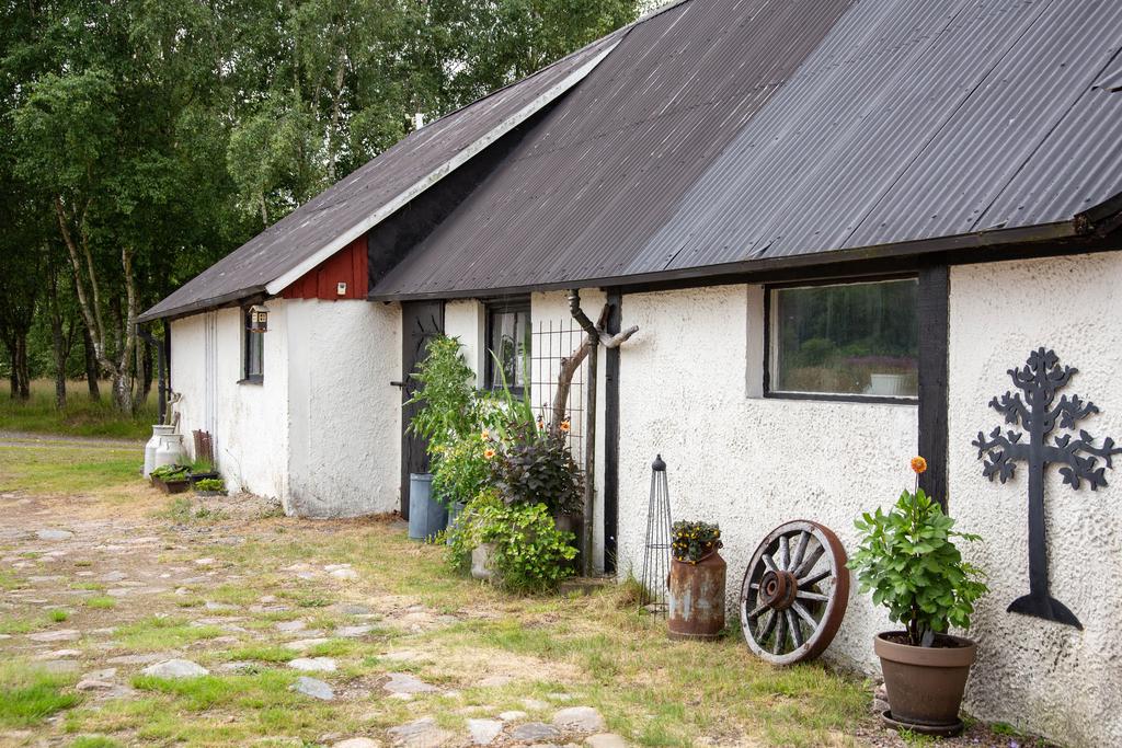 Fin ladugård med vit fasad – här finns förråd och stallutrymmen.