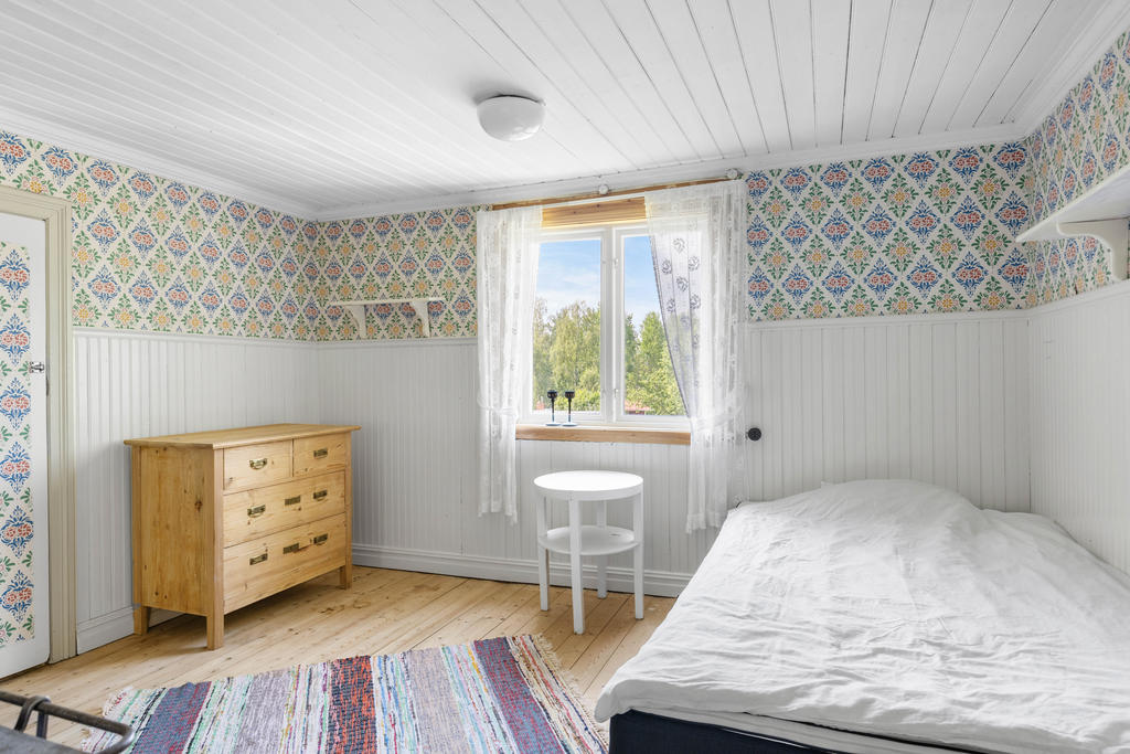 ÖV: Sovrum 1, beläget i det gamla köket med klassisk Hälsinge-tapet (Gästgivars). 
