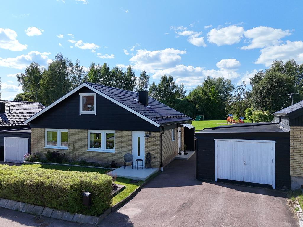 Den välkomnande entrén med altan och garage.